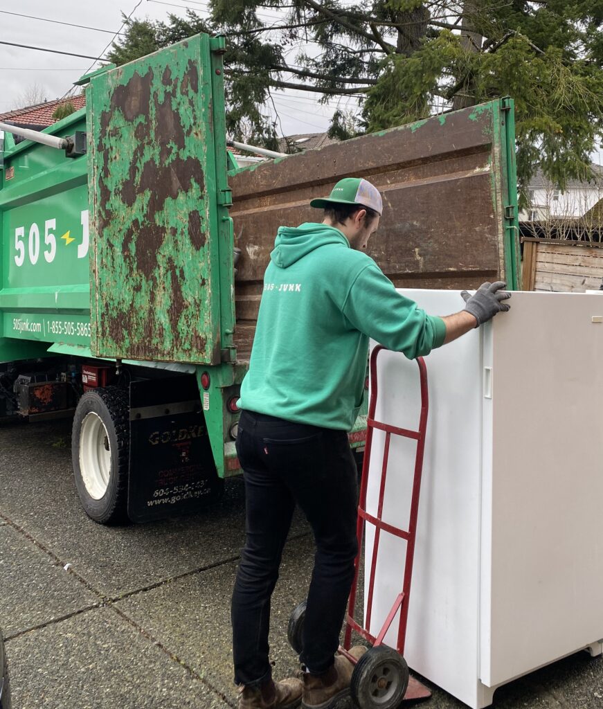 A 505-Junk employee rolling a fridge on a dolly to the truck during an appliance removal in North Vancouver.