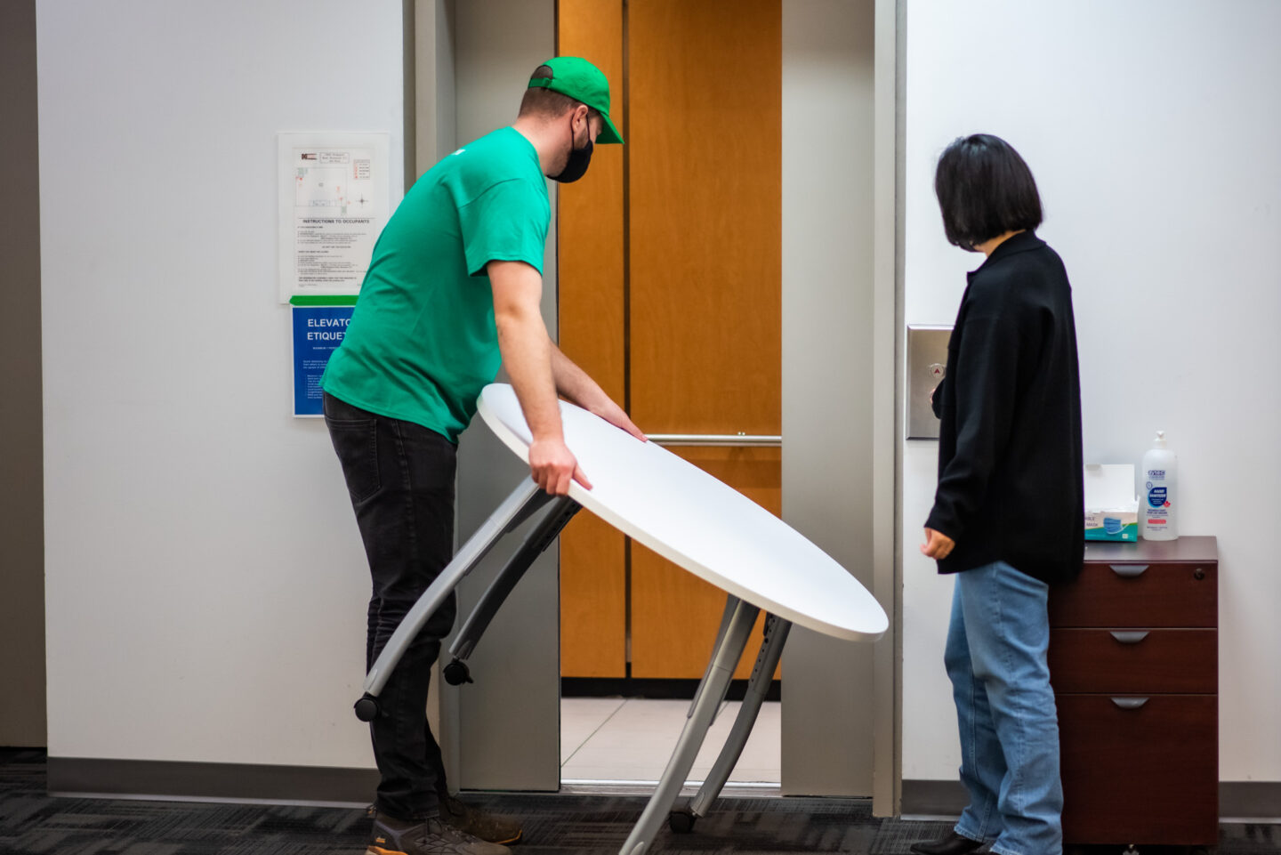 A 505-Junk employee taking a big table into the elevator during an office junk removal pickup. 