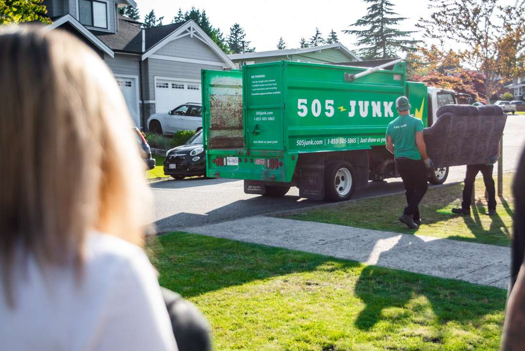 Two 505-junk employee removing couch during a junk removal in North Vancouver