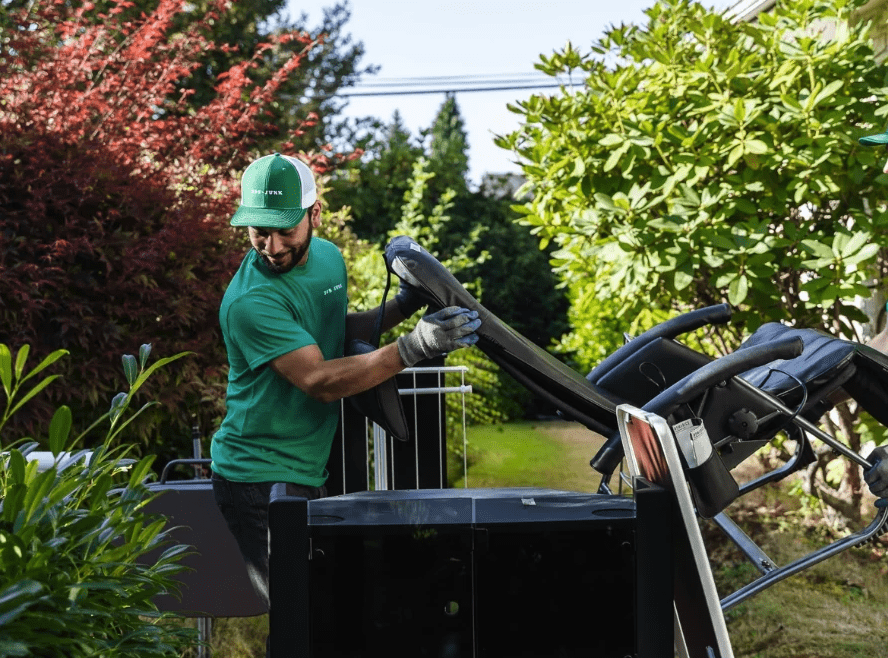 A 505-Junk employee carrying a chair to the truck during a furniture removal in Burnaby.