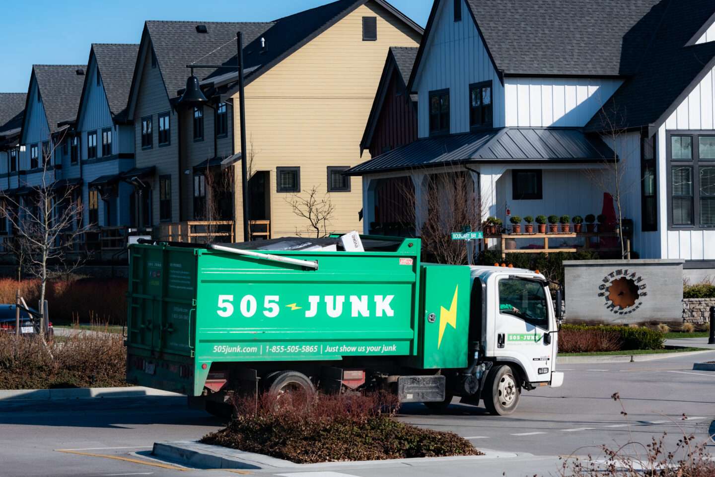 A 505-Junk truck driving through a community for a junk removal near me.