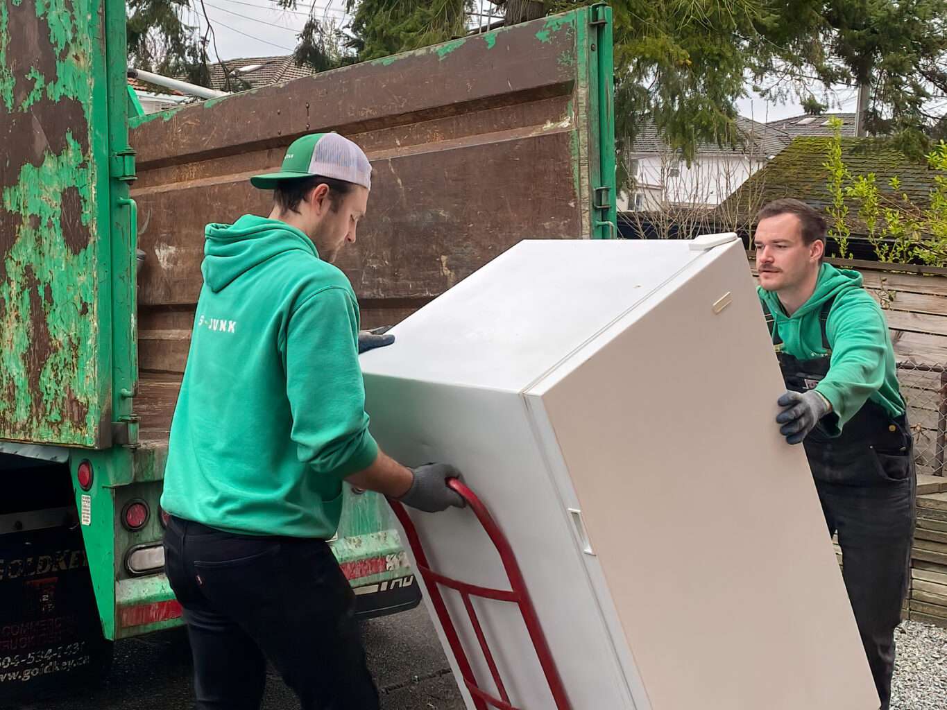 Our team members loading a fridge into the truck during an appliance removal in Burnaby and an appliance removal in Surrey