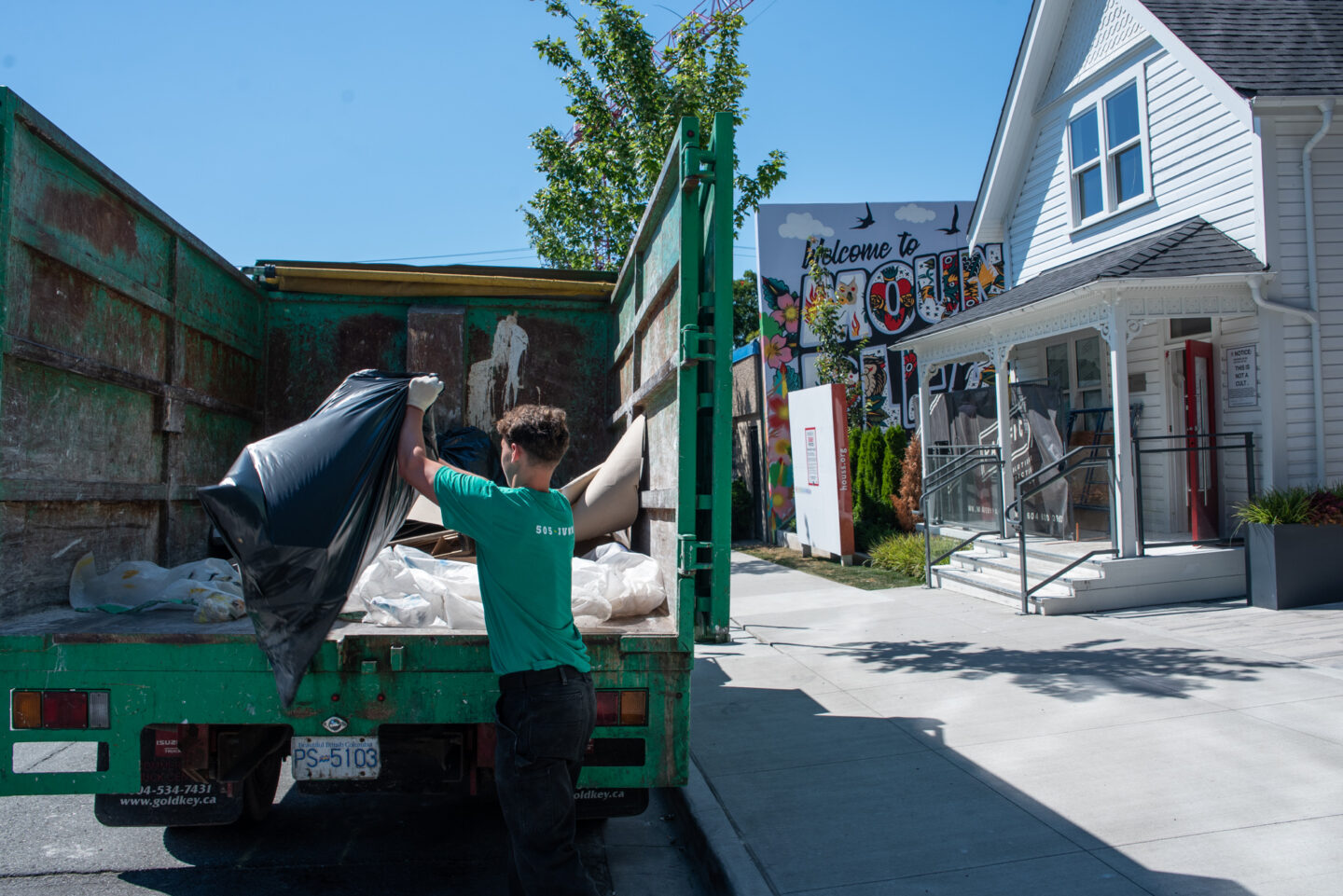 A 505-Junk employee throwing junk into the back of a truck during a construction debris removal in North Vancouver.
